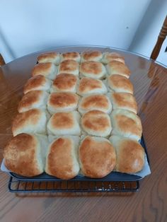 a large loaf of bread sitting on top of a metal rack next to a wooden table