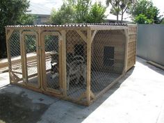 a dog in a wooden kennel on the sidewalk