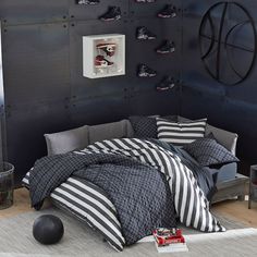 a bedroom decorated in black and white with striped comforter, pillows, and bedding