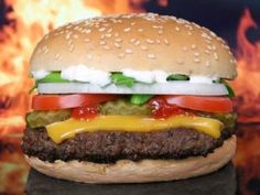 a cheeseburger with tomatoes, lettuce and tomato slices on it's bun