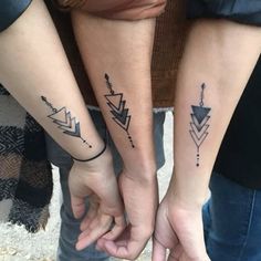 two people are holding hands with tattoos on their arms and the other hand has an arrow