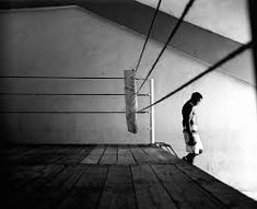 a man standing on top of a wooden floor next to a boxing ring