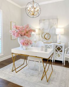 a living room with white furniture and flowers in the vase on the coffee table, chandelier hanging from the ceiling