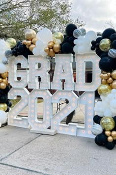 a large sign that says graduation with balloons around it