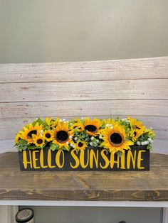 a wooden sign with sunflowers and the words hello sunshine on it sitting on a table