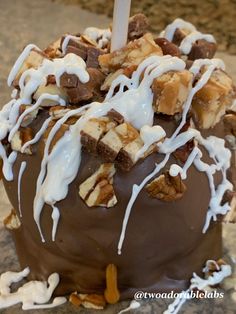 a chocolate cake with white icing and nuts on top