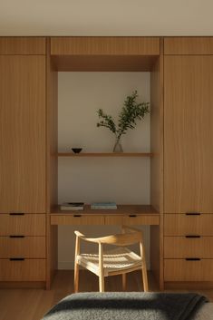 a wooden desk with a chair in front of it next to a wall mounted shelf