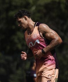 a man running on a field with trees in the background