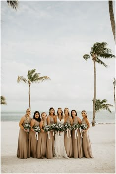 a group of women standing next to each other on top of a beach