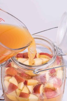 a glass jar filled with liquid and sliced apples