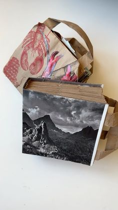 an open book sitting on top of a table next to a wooden basket filled with pictures