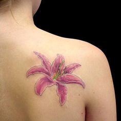 a woman with a pink flower tattoo on her back