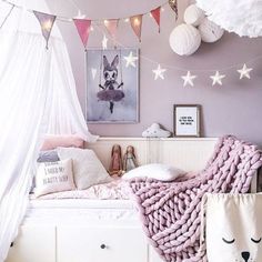 a bedroom decorated in pink and white with decorations on the ceiling, bedding, rugs and pillows