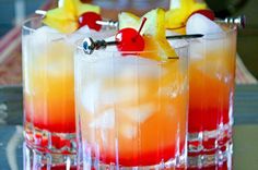 two glasses filled with drinks sitting on top of a table