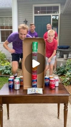 a group of people standing around a table with cans on it