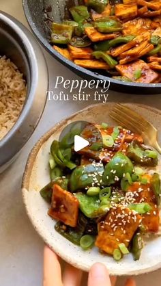 someone is holding a plate with tofu and green beans on it next to a bowl of rice