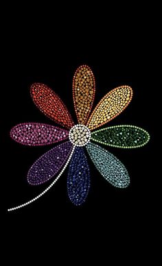 an image of a flower made out of beads on a black background in the dark