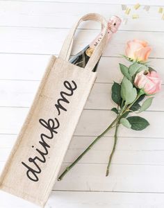 a wine bottle in a bag next to some flowers