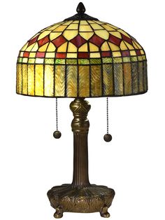 a lamp that is sitting on top of a wooden stand with a glass shade over it