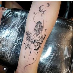 a woman's leg with a tattoo on it and a fairy holding a flower