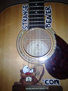 an acoustic guitar with stickers on it