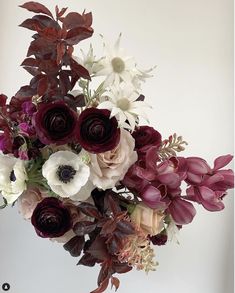 a vase filled with lots of flowers on top of a table