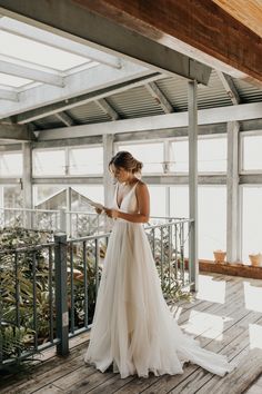 a woman in a wedding dress standing on a deck