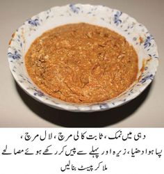 a bowl filled with food sitting on top of a table next to an arabic text