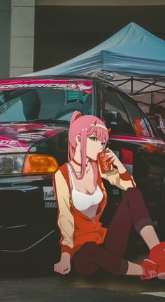 a woman sitting on the ground next to a parked car and eating a donut