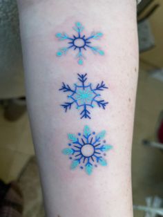 an arm with three snowflakes on it and one is blue, the other is white