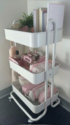 a three tiered white shelf with books, magazines and other items on it's sides