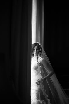 a woman standing in front of a window wearing a veil