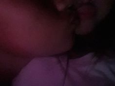 two people that are kissing each other in front of a light up cell phone screen