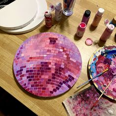 a wooden table topped with lots of crafting supplies and paint on top of it