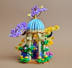 a small building made out of legos and flowers