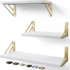 two white shelves with gold brackets on them