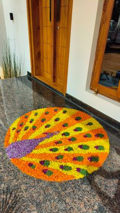 a large flower arrangement on the ground in front of a door