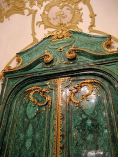 an ornate green cabinet with gold trimmings