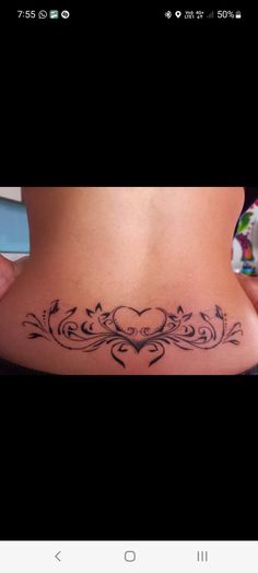 a woman's stomach with a heart and vines tattoo on the side of her belly