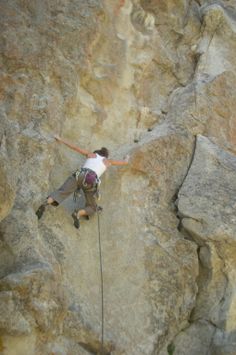 a man climbing up the side of a mountain