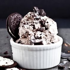 an ice cream sundae with oreo cookies and chocolate chips in a white bowl