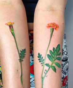 two flower tattoos on both legs with green leaves and orange flowers painted on the thighs