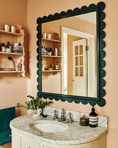 a bathroom sink under a large mirror in front of a shelf with shelves on it