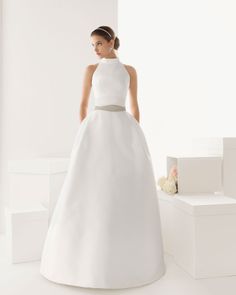 a woman in a white wedding dress standing next to some boxes and flower bouquets