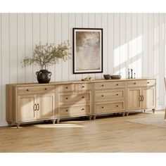 a wooden sideboard with two vases sitting on top of it next to a chair