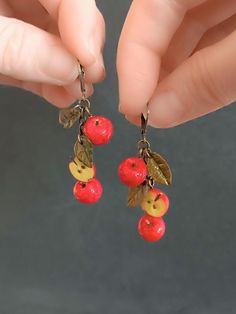 If you  If you're looking for a unique and unusual earrings, then you're in the right place! This delightful red Apple earrings would make a wonderful a lovely treat for friend, sister, girl, mom, and yourself!The  apple earrings features a realistic miniature red apple charm handcrafted using polymer clay.Each apple measures approx. 1 cm length These earrings are very lightweight and won't feel heavy on your earlobe, ensuring all-day comfort. The earring hooks are made from nickel-free and lead-free metal, making them safe and comfortable for sensitive ears.  size English earwires 16 *10 mm.  color: antique bronze  Check out other listings from my workshop. Thank you for your purchases! Fruit Collection  https://www.etsy.com/shop/miniwarsztat?ref=l2-about-shopname&from_page=listing§ion_id Red Clip-on Earrings As Gift, Red Whimsical Nickel-free Earrings, Whimsical Red Nickel-free Earrings, Novelty Red Pierced Earrings, Whimsical Red Dangle Jewelry, Whimsical Red Drop Earrings, Red Novelty Drop Earrings, Novelty Red Earrings For Gift, Whimsical Handmade Red Earrings