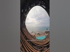 an aerial view of a pool and the ocean from inside a large metal pipe structure