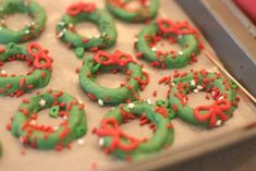 green and red decorated donuts sitting on top of a pan