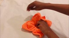 someone is cleaning the bed with an orange towel