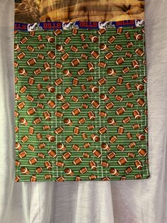 a green and orange tie with footballs on it